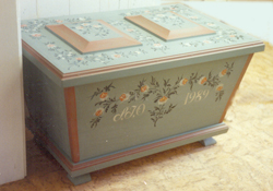 Delsbo
                        kista i mild gråblå oljefärg. Dekorerad med
                        blommor i svaga pastellfärger.